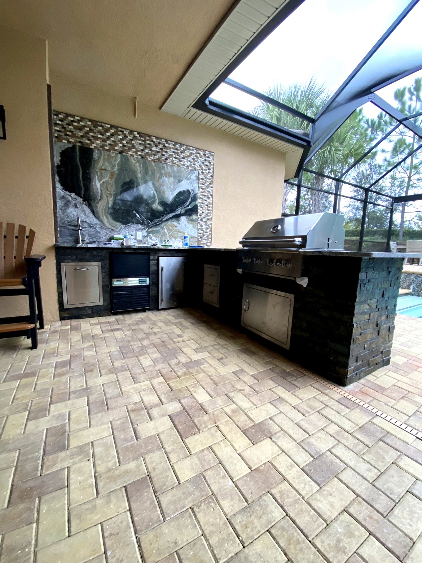 L-shaped outdoor kitchen with stone base and granite counters — Tampa Bay, Florida
